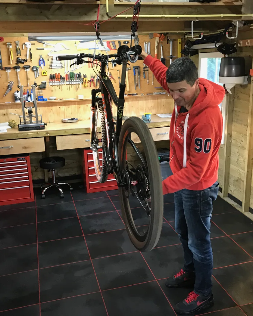 Eric controleert een fiets in zijn werkplaats